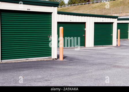 Nouveau mini entrepôt de stockage bâtiments avec portes vertes et un parking vide. Banque D'Images