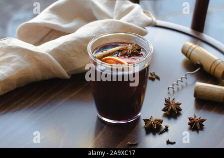 Verre de vin chaud fait maison avec différentes épices sur chaise en bois. Boisson d'hiver parfait pour le froid. Banque D'Images