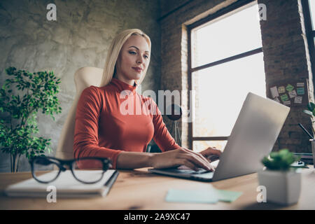 L'angle ci-dessous bas voir photo de dame d'affaires qualifiés travaillant sur son projet en utilisant laptop sitting at desktop Banque D'Images