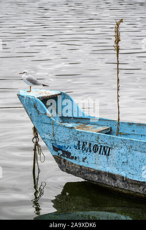 Une mouette perchée sur un bateau de pêche sur le lac Orestiada à Kastoria la Macédoine, la Grèce du Nord. Banque D'Images