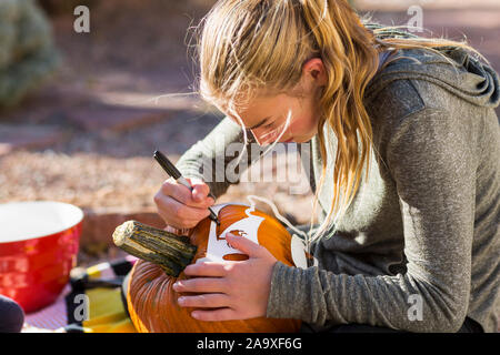 La sculpture d'une adolescente à l'extérieur à la citrouille Halloween. Banque D'Images