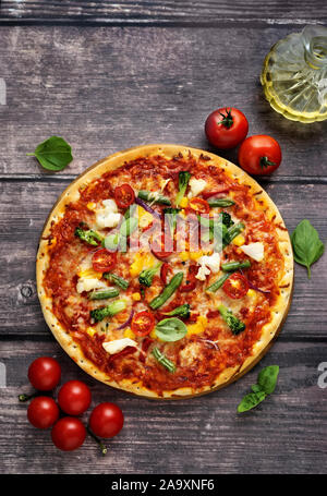 Vue de dessus de pizza végétarienne faits maison servis sur table en bois dans un style rustique Banque D'Images