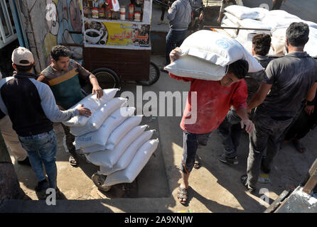 La ville de Gaza. 18 Nov, 2019. Les réfugiés reçoivent des aliments fournis par l'organisation des secours et de travaux des Nations Unies pour les réfugiés de Palestine dans le Proche-Orient (UNRWA) dans un camp de réfugiés dans la ville de Gaza, le 18 novembre 2019. La Quatrième Commission de l'Assemblée générale des Nations Unies a voté vendredi dernier de proroger le mandat de l'Office de secours et de travaux des Nations Unies pour les réfugiés de Palestine dans le Proche-Orient (UNRWA) jusqu'en 2023. Abdeljawad Crédit : Rizek/Xinhua/Alamy Live News Banque D'Images