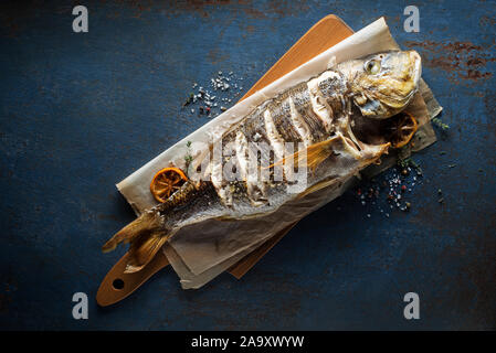 La chair de poisson délicieux grillés aux épices et citron sur fond bleu vintage. Régime alimentaire sain de manger ou de concept de cuisine Banque D'Images