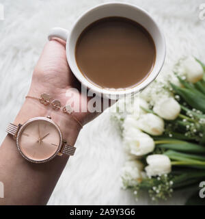 C'est un temps pour le café. Femme avec une main Golden Watch Holding tasse de café chaud pour se réveiller au matin Banque D'Images