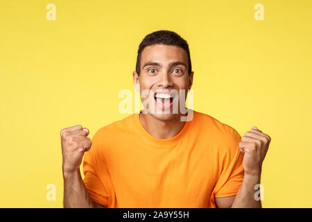 Réalisation, de célébration et de gagner concept. Beau jeune homme gai soulagé mains clench, fist et pompe smiling devenir gagnant ou champion, recevoir Banque D'Images