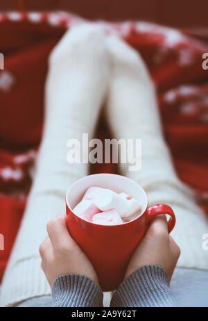 Woman holding mug chaud avec du chocolat dans les mains et de porter des chaussettes amusantes Banque D'Images