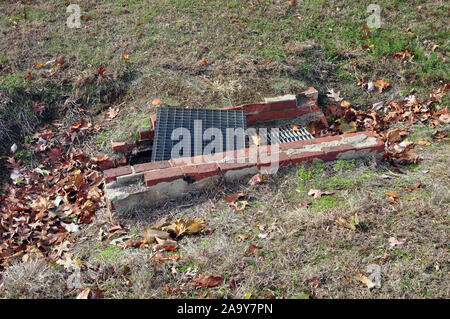 Une grille de drainage fait de briques et de métal. Banque D'Images