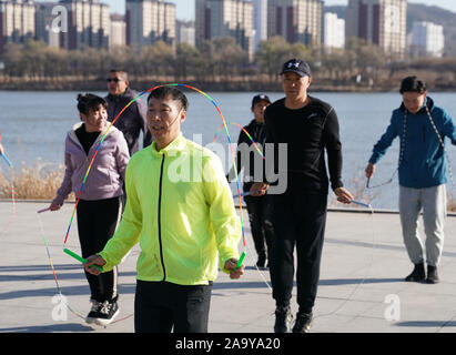 (191118) -- BEIJING, 18 novembre 2019 (Xinhua) -- Hou Weidong (avant) pratiques avec ses élèves sur une place dans la ville de Jilin, Province de Jilin du nord-est de la Chine, le 5 novembre 2019. Hou Weidong, 41 ans, est un entraîneur national qui se spécialise dans les soins de bébé. Entre-temps, il est également un athlète professionnel de saut à la corde. Au début, saut à la corde était juste son programme de conditionnement physique quotidienne dans le parc. Peu à peu, son étonnante performance a attiré beaucoup de gens d'apprendre de lui, alors il s'est engagé dans un chemin d'entraînement. En 2014, lui et ses étudiants ont commencé à assister aux compétitions de saut à la corde et Banque D'Images