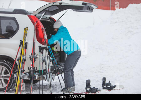 KAZKOVA POLIANA, UKRAINE - le 26 janvier 2019 : Rencontre femme à ski. voiture avec coffre ouvert Banque D'Images