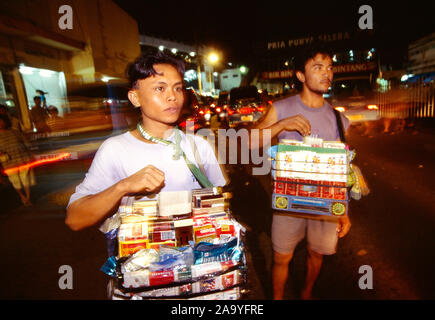 L'Indonésie. Sulawesi. La ville de Manado. Les marchands de produits du tabac dans la nuit. Banque D'Images