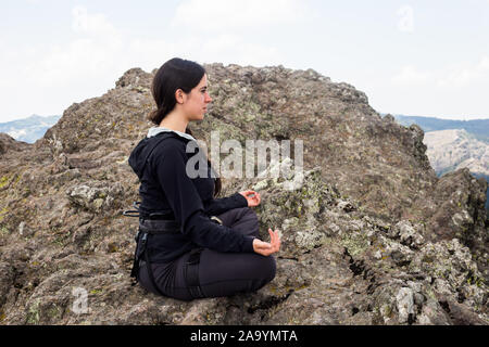 Les jeunes climber woman doing yoga dans la montagne. Banque D'Images