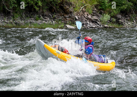 Woman paddling un kayak gonflable sur la rivière Grande Ronde de l'Oregon. Banque D'Images