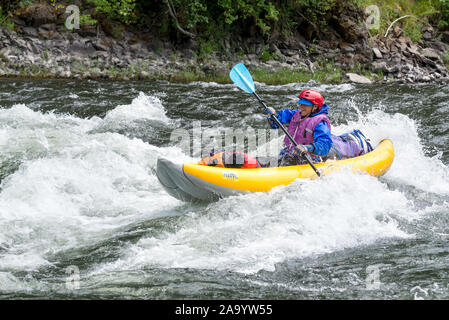 Woman paddling un kayak gonflable sur la rivière Grande Ronde de l'Oregon. Banque D'Images