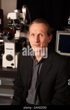 Close-up portrait of Peter C Searson, professeur d'ingénierie et de la science des matériaux, assis en face d'un microscope et faisant face à la caméra, à l'Université Johns Hopkins University, Baltimore, Maryland, le 4 mars 2009. À partir de la collection photographique de Homewood. () Banque D'Images