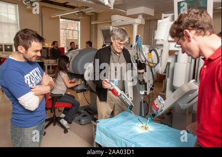 Russell Taylor, le John C Malone, professeur d'informatique, saisit un robot chirurgical da Vinci's arm alors que Whiting School of Engineering students regarder la machine effectuer une simulation d'opération à l'Université Johns Hopkins, Baltimore, Maryland, le 6 avril 2009. À partir de la collection photographique de Homewood. () Banque D'Images