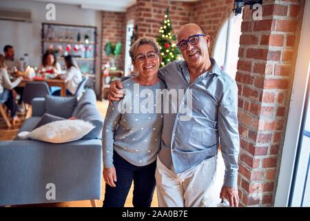 La famille et les amis des repas maison pour célébrer la veille de Noël avec de la nourriture traditionnelle et la décoration, romantic senior couple hugging in love Banque D'Images