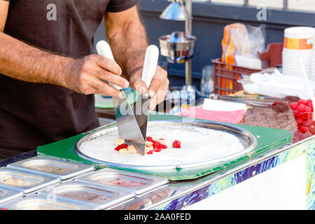 L'homme est la cuisine Thai sweet street food incorporer la crème glacée frite roule à geler la casserole. Banque D'Images