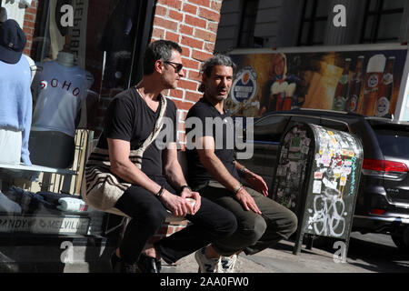 Les hommes adultes s'asseoir et parler sur la rue dans Nolita, Manhattan, New York. Banque D'Images