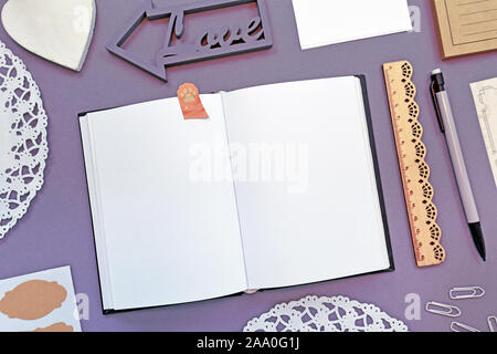 Vue de dessus télévision coucha avec divers bureau bien agencées avec des fournitures de bureau comme des crayons, règle, blocs-notes, les broches et ouvert au début de l'ordinateur portable vide f Banque D'Images