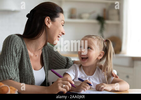 Petite fille de communiquer avec maman au cours de cours de dessin. Banque D'Images