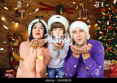 Mère regardant fille mettre Santa barbe père Banque D'Images