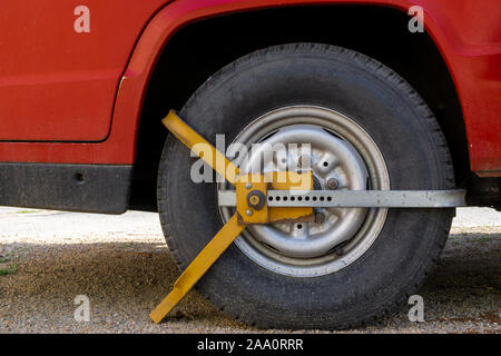 Roue de voiture bloquée par blocage de roue parce que le stationnement illégal violation Banque D'Images