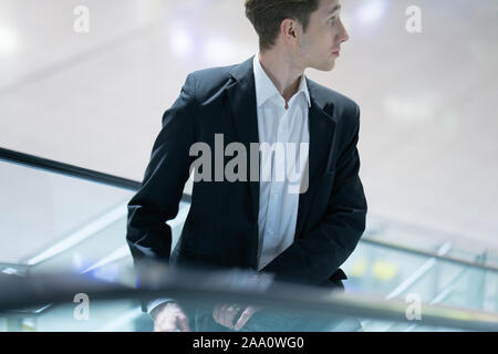 Close up of a young handsome businessman sur un escalier dans un immeuble de bureaux en costume Banque D'Images