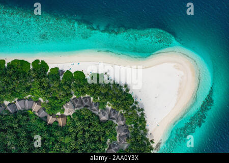 Vue aérienne de haut en bas avec vrombissement d'une île exotique tropical paradise avec une eau cristalline turquoise et plage de sable blanc pur Banque D'Images