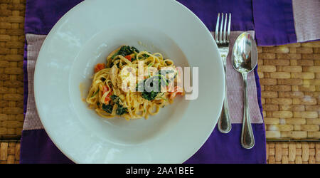 Carbonara faites maison sur plaque bleue avec cuillère et fourchette Banque D'Images