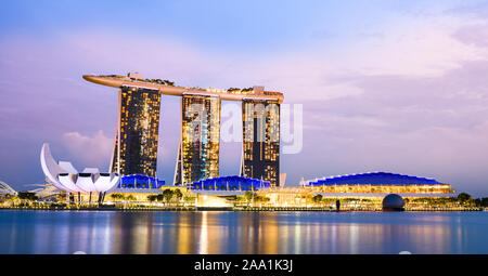 Vue imprenable sur la Marina Bay skyline avec de beaux gratte-ciels illuminés au cours d'un splendide coucher de soleil à Singapour. Banque D'Images