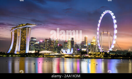 Vue imprenable sur la Marina Bay skyline avec de beaux gratte-ciels illuminés au cours d'un splendide coucher de soleil à Singapour. Banque D'Images