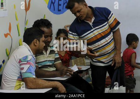 Kuala Lumpur, Selangor, Malaisie. 11Th Nov, 2019. Un enseignant bénévole aider un étudiant plus âgé à l'académie.Rohingyas English Academy est un centre d'apprentissage qui offre une éducation gratuite pour les réfugiés rohingyas les enfants et les adultes, elle a été fondée par Saif Ullah un citoyen Rohingya vivant en Malaisie et aussi un professeur d'anglais à l'académie qui ne reçoit aucune aide du gouvernement. La Malaisie a enregistré plus de 177 690 réfugiés et demandeurs d'asile de Rohingyas statistique selon le HCR et 45 470 d'entre eux sont des enfants de moins de 18 ans. (Crédit Image : © Faris Hadziq/SOPA v Images Banque D'Images