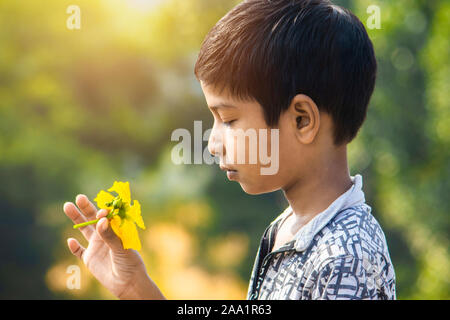 Sijhora India-November, Madhya Pradesh, 19, 2019.Portrait petit garçon indien holding luffa fleur en parc. Banque D'Images