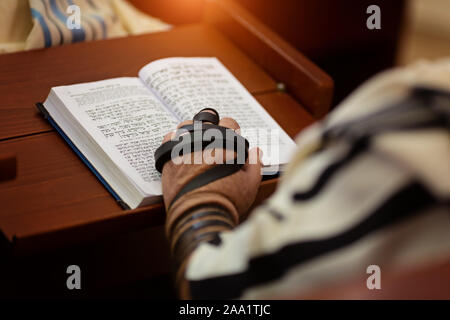 La lecture de la prière juive et une main avec tefillin Banque D'Images