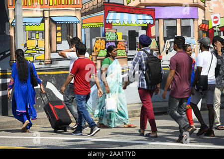 Certaines personnes sont à pied devant un beau graffiti peint sur un mur dans Little India. Banque D'Images