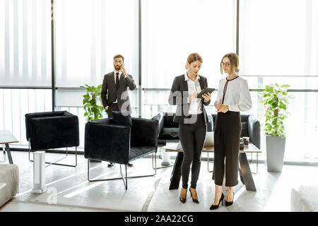 Les employés de l'institution financière ou d'autres grands copany ayant quelques affaires, debout et parler dans le bureau de luxe Banque D'Images