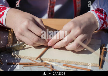 Les mains d'un artisan faire un métier à partir de la paille. Produit fait main Banque D'Images