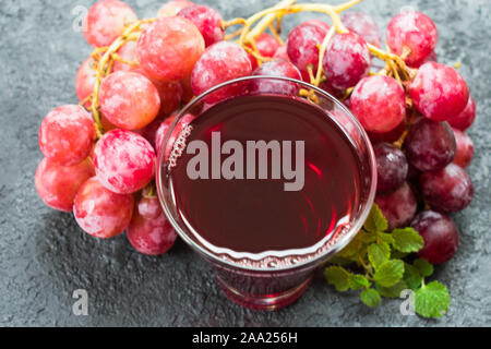 Verre de jus de raisin et d'une succursale de raisins sur un fond noir. Vue d'en haut. Banque D'Images