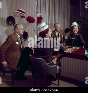 Essayer des chapeaux dans les années 1950. Un couple est assis en face d'un miroir à essayer des chapeaux sur. Il est humoriste Erik Zetterström et elle est Sickan Carlsson, actrice. Suède 1950 Banque D'Images