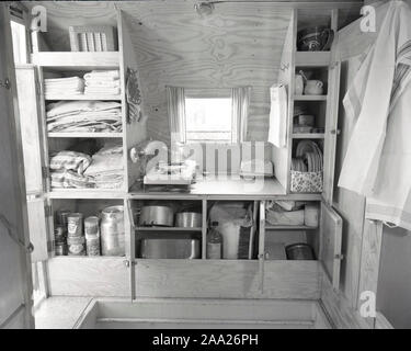 Années 1950 Le camping. Une famille, c'est jouir de leur maison de vacances et de la vie de camping pratiques dans leur caravane. Montrer comment tout fonctionne bien pour eux, même en vacances. La photo montre le rangement pratique pour les casseroles, assiettes et tasses. La Suède 1952 Ref 2021 Banque D'Images