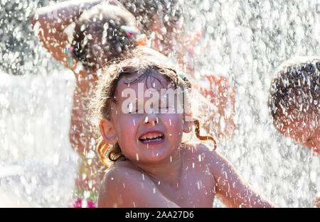 La Russie, Peterhof, le 27 juillet 2019. Rue de la ville. Les enfants se baignent dans la fontaine. Visage de l'enfant dans l'eau de pulvérisation. Banque D'Images