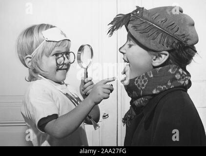 Médecin jouant dans les années 40. Une petite fille est le médecin dans ce jeu et regarde ses frères gorge comme un vrai médecin. Suède 1948 Banque D'Images