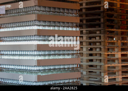 Territoire de la verrerie avec paniers de bouteilles. Beaucoup de produits de verre dans du cellophane. L'emballage en verre Banque D'Images