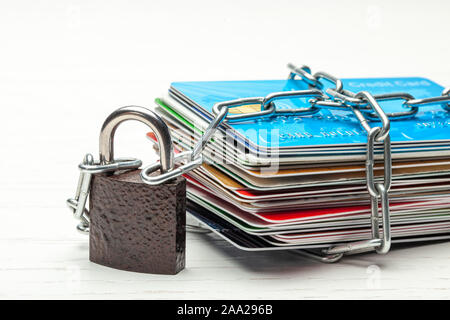 Pile de cartes de crédit et d'un cadenas avec chaîne isolé sur un fond blanc. Fermé l'accès aux cartes de crédit, bloquée, serrure. Banque D'Images