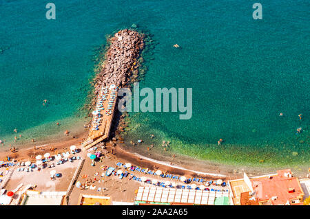 Vue de dessus sur les pierres rocheuses marinas sur la plage plein de touristes, de transats, parasols sur la mer Tyrrhénienne, près de la baie de Sorrente et méta villes en Na Banque D'Images