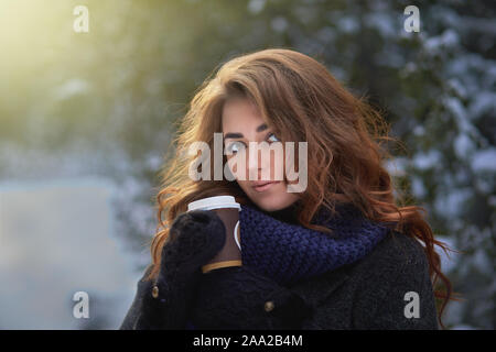 Belle jeune femme avec de naturel et de longs cils détient avec du café chaud ou un thé. Banque D'Images