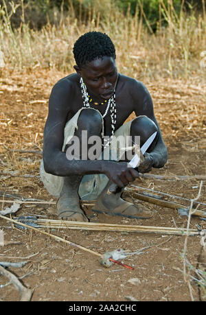 Hunter Hadzabe qui composent le feu avec des bâtons. Lake Eyasi, du nord de la Tanzanie. Banque D'Images