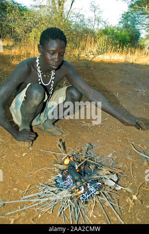 Bushman Hadzabe qui composent un feu. Lake Eyasi, du nord de la Tanzanie. Banque D'Images