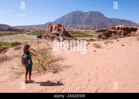 Photographier une femme avec mobile une vue panoramique à la Quebrada de las Conchas avec la rivière Las Conchas en arrière-plan, Cafayate, Argentine Banque D'Images